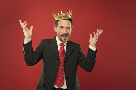 His dream of being champion came true. Crowned champion smiling with crown on red background. Happy...
