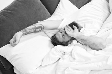 Relax and sleep concept. Man bearded guy sleep on white sheets. Healthy sleep and wellbeing. Man bearded hipster sleepy in bed. Early morning hours. Insomnia and sleep problems. Lets start new day.の写真素材