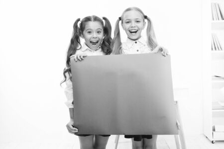 Fantastic information. Little girls holding blank paper sheet for information on white background. Small kids with blank pink poster for school information. Place for your information, copy spaceの写真素材