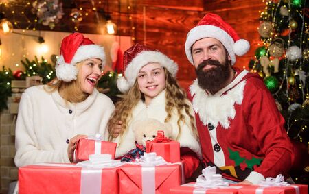 We love Christmas. Happy family celebrate new year. Winter holidays. Shopping sales. merry christmas. Father and mother love daughter. xmas gift boxes. small child and parents in santa hatの写真素材