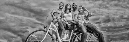 Share or rental bike service. Bicycle as best friend. Company stylish young people spend leisure outdoors sky background. Cycling modernity and national culture. Group friends hang out with bicycleの写真素材