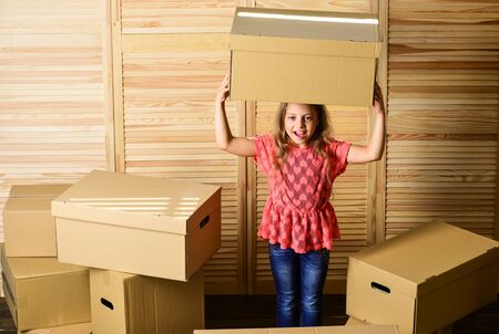 Happy little girl sit in room on boxes.