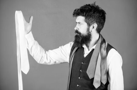 In clothing shop. Shop assistant offering wide choice of finest neckties. Bearded man choosing luxury necktie in menswear shop. Shop for mens clothes and accessoriesの写真素材