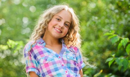 natural beauty. small girl long culry hair. happy childhood. perfect healthy skin. youth is brilliant. summer holidays and vacation. enjoy good weather. kid fashion. pretty child outdoorの写真素材