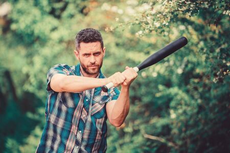 Strong temper. Principle concept. Confident in his strength. Bully guy in nature with cudgel. Wild energy. Power and strength. Feel my strength. Man unshaven strict face hold black baseball batの写真素材