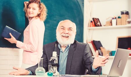 Biology science. Study biology. Biological research. Teacher and girl with notepad near chalkboard....
