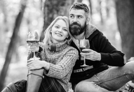 couple in love relax in autumn forest. Family picnic. Valentines day. love date and romance. Spring mood. camping and hiking. cheers. happy woman and bearded man drink wine. Sommelier at workの写真素材