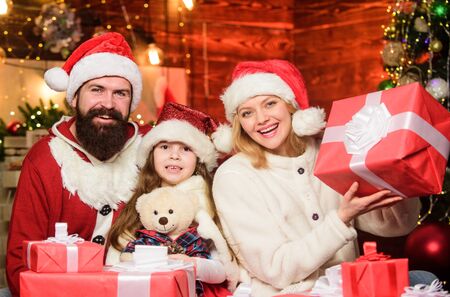 Joyful people. Gifts from Santa. Lovely daughter with parents. Christmas traditions concept. Father Santa claus costume with mom and little kid celebrating christmas. Christmas is the time to pleaseの写真素材