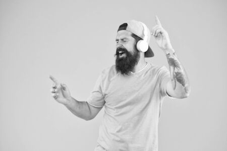Inspiring song. Music library. Feel rhythm. Bearded guy enjoy music. Equalizer player settings. Lifestyle music fan. Man listening music wireless headphones. Bass low sound. Hipster headphones gadget.の写真素材