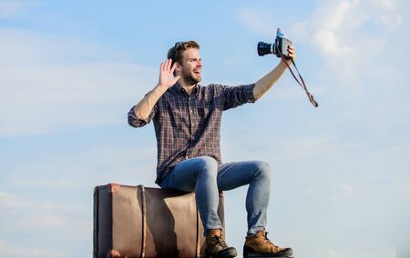 Travel blogger. Handsome guy traveler retro camera. Travel with luggage. Shooting vlog. Vacation...