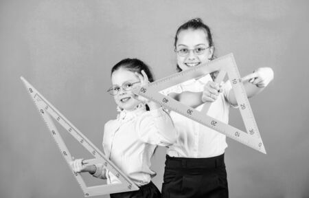 STEM school disciplines. small girls back to school. math lesson. Education and knowledge. Pupil cute girls with big rulers. School students learning geometry. Education. best friendsの写真素材