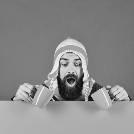 Hipster with beard and shocked face. Beverages and English autumnの写真素材