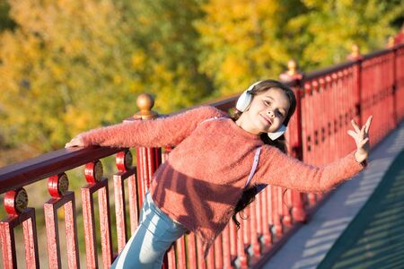 Ballet dancer. Music for autumn cozy mood. Listening songs. Melody for good mood. Enjoy music outdoors fall warm day. Audio file. Kid girl dancing with modern wireless headphones. Classy styleの写真素材