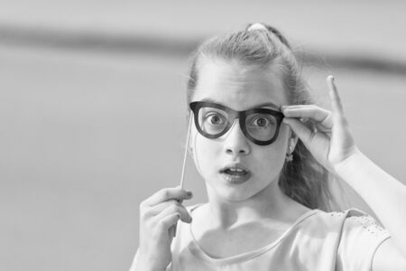 Nice day to have fun with photo booth props. Girl carefree child having fun. International childrens day. Happiness joy and fun concept. Kid long hair happy smile face. Summer holidays. Fun and humorの写真素材
