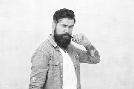 Hipster with beard and mustache wear denim shirt. Male beauty concept. Brutal handsome hipster man on grey wall background. Bearded man trendy hipster style. Barber salon. Well groomed machoの写真素材
