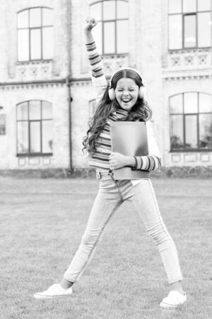 She has a really lovely singing voice. Small singer learning to sing with singing books. Happy little girl child singing along to her favorite song playing in earphones. Singing makes her happyの写真素材