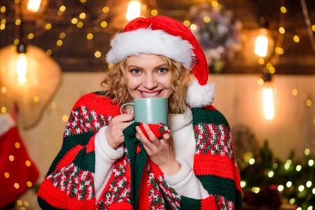 Tea shop concept. Warm and cozy. Cozy home. Enjoy cozy atmosphere of winter holidays. Woman drink tea christmas decorations background. Relax and recharge. Girl with mug of hot beverage relaxingの写真素材