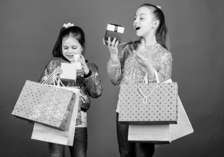Black friday. Sale and discount. Shopping day. Children bunch packages. Kids fashion. Girls sisters friends with shopping bags blue background. Every product delivered to you. Shopping and purchaseの写真素材