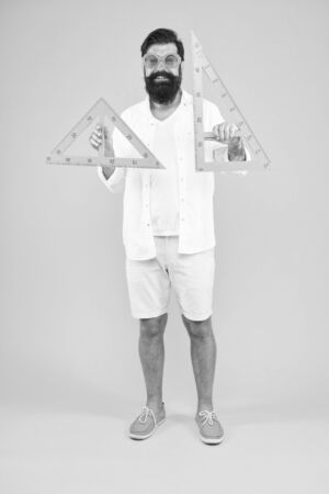 Triangle is the most important shape in engineering. Engineer using triangles for making engineering drawings. Bearded man teaching engineering discipline. Engineering and designの写真素材