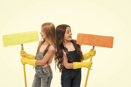 Girls with protective gloves and mops ready for cleaning. Household duties. Sisters little helpers. Girls cute kids cleaning around. Keep it clean. Get rid of dust. Helpful kids cleaning togetherの写真素材