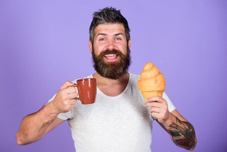 be happy. Morning tradition concept. Fresh baked croissant. Delicious breakfast. Unhealthy but yummy breakfast. Perfect match. feel hunger. Bearded hipster enjoy breakfast drink coffeeの写真素材