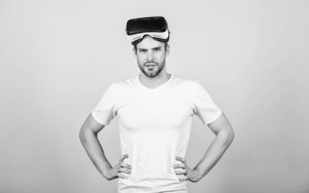 VR for gaming. Man play game in VR glasses. Man hipster with virtual reality headset on peach background. Explore cyber space. Entertainment and education. Virtual communication. Virtual simulationの写真素材