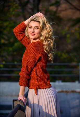 Autumn stylish outfit. Fall fashion. Adorable lady enjoy sunny autumn. Woman walk in autumn park. Cozy knitwear. Knitted sweater. Fashionable clothes. Girl gorgeous blonde. Femininity and tendernessの写真素材