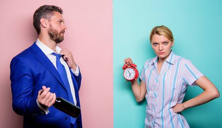 no time for jokes. problems in relationship. family psychology. unhappy life. man drink wine. woman show time on alarm clock. wife wondering why husband reveler came home so late. family routineの写真素材
