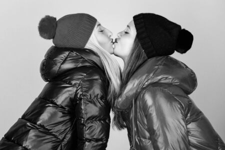 Glad to see you. Best friends forever. Winter kiss. Best friends matching outfits. Soulmates girls kiss. Women wear down jackets. Girls makeup face wear winter jackets. Fashion trend. Winter seasonの写真素材