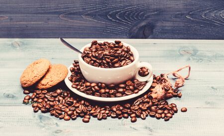Cafe drinks menu. Arabica robusta coffee variety. Beverage for inspiration and energy charge. Cup full coffee brown roasted bean blue wooden background. Fresh roasted coffee beans. Caffeine conceptの写真素材