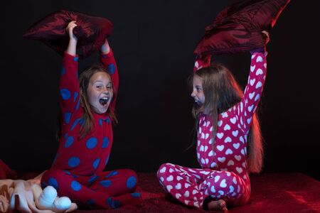 PJs party for children: girls shouting and fighting with pillowsの写真素材