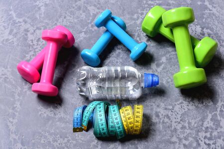 Dumbbells made of pink, green and cyan plasticの写真素材
