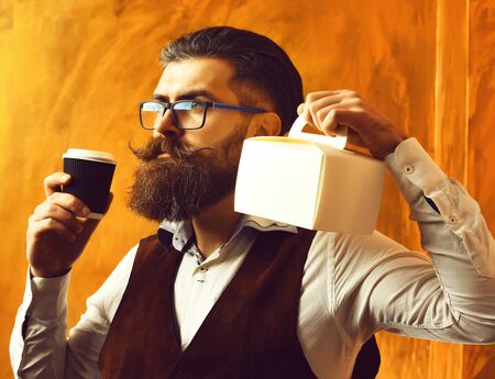 Bearded man, brutal caucasian hipster holding coffee and meal boxの写真素材