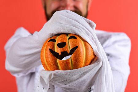 Halloween decorations concept. Man holds decor item on red backgroundの写真素材