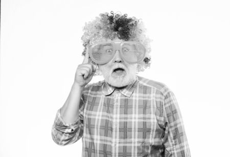 Nice joke. Elderly clown. Man senior bearded cheerful person wear colorful wig and sunglasses. Grandpa always fun. Having fun. Funny lifestyle. Fun and entertainment. Comic grandfather conceptの写真素材
