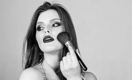 Skin tone concealer. Cosmetics shop. Emphasize femininity. Girl apply eye shadows. Woman applying makeup brush. Professional makeup supplies. Different brushes. Skin care. Makeup cosmetics conceptの写真素材