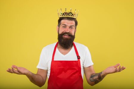 Kitchen is my kingdom. Cook with beard and mustache yellow background. Royal recipe. Man king cook wear cooking apron and golden crown. Ideas and tips. Chief cook and professional culinary. Cook foodの写真素材