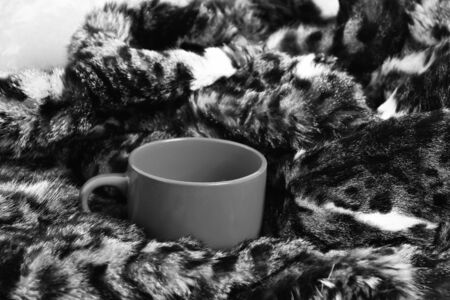 Orange tea, coffee cup or mug on fur coat backgroundの写真素材