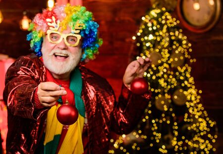 this is for you. party man in clown wig. happy man with beard. mature bearded freak. new year weekend. Fanily holiday. christmas tree decoration. Going crazy. xmas gifts. Time for presentsの写真素材