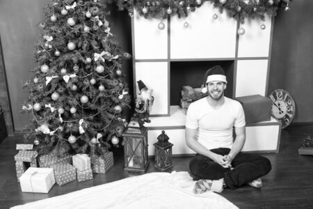 Man in santa hat smile at fireplaceの写真素材