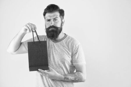 Male motives for shopping appear to be more utilitarian. Aspects can influence customer decision making behavior. Hipster hold shopping bag. Man with purchase. Impulse purchase. Purchase conceptの写真素材
