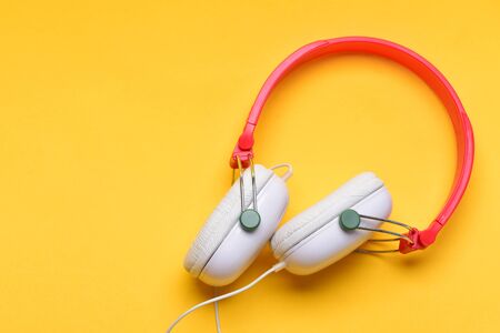 Hobby, leisure and music concept. Headphones in white and red color with wire. Modern and stylish...