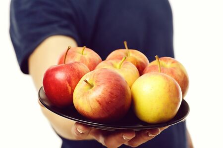 Plate of red and yellow apples on males handの写真素材