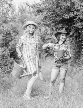 This flower is yours. farming and agriculture. spring country side. earth day. summer family farm. children hold gardening tools. small girls farmer in village. ecology and environmental protectionの写真素材