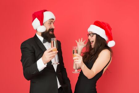 Christmas fun. formal couple visiting event ceremony. tuxedo man with woman in santa hat. merry christmas. business couple drink champagne. xmas office party. they love new year. greetings concept.の写真素材