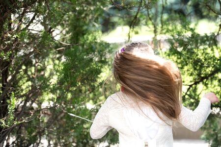 Girl dancer with long flying hair. Kid dance to music in summer park. Small child enjoy music in headphones outdoor. Melody sound and mp3. Summer fun and joy.の写真素材