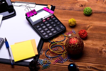 Stationery, calculator and xmas balls. Clip folder with white paper, elastics, pen and clips on...