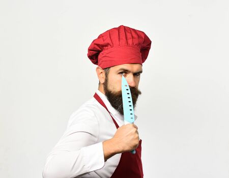 Chef holds sharp blue knife near eye.の写真素材