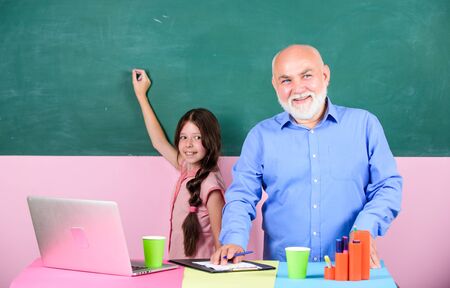 Mature teacher help school girl help study on laptop.の写真素材