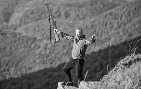 Walking in mountains. Hunting masculine hobby concept. Regulation of hunting. Hunter hold rifle. Nice day for hunt. Hunter spend leisure hunting. Man brutal gamekeeper nature landscape backgroundの写真素材